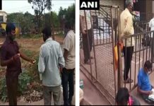अखबार पढ़ते और चाय पीते हुए शराब की दुकान खुलने का इंतजार कर रहे लोग